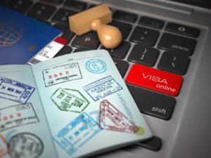 Open passport with multiple visa stamps resting on a laptop keyboard