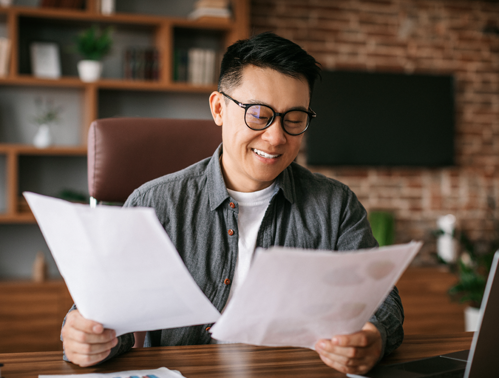 Extreme Hardship Waivers. A man looking at paperwork and smiling.