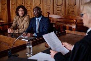 Two male attorneys looking at a female judge in a courtroom.