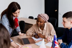 Asylum seekers attending a language learning class, using laptops and teamwork to support integration and resettlement